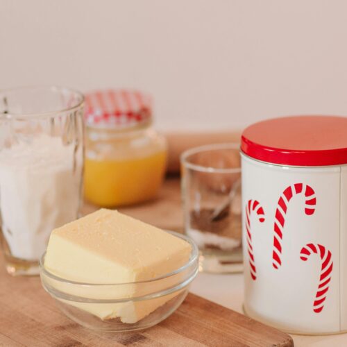 A cozy setup for holiday baking featuring butter, flour, and festive candy cane jars.